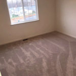 an empty room with carpet and a window