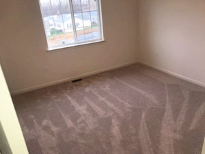 an empty room with carpet and a window