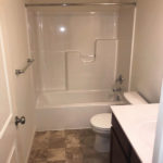 a white toilet sitting next to a bath tub