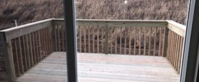 a wooden deck in front of a sliding glass door