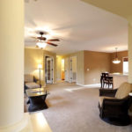 a living room filled with furniture and a ceiling fan