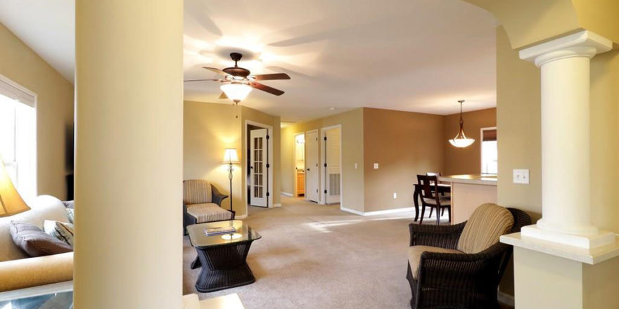 a living room filled with furniture and a ceiling fan