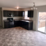 an empty kitchen with black cabinets and appliances