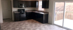 an empty kitchen with black cabinets and appliances
