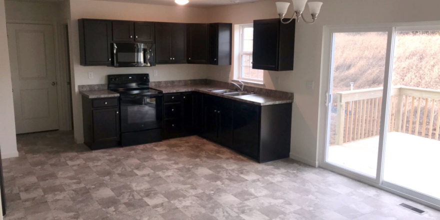 an empty kitchen with black cabinets and appliances