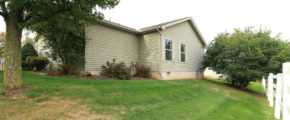 Exterior rear of home with pastel green siding and large yard