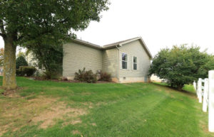 Exterior rear of home with pastel green siding and large yard