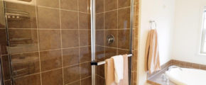 a bathroom with a glass shower door and tiled walls