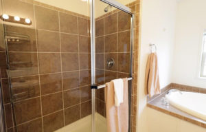 a bathroom with a glass shower door and tiled walls