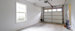 an empty garage with two windows and a door