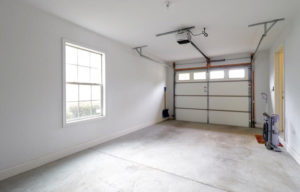 an empty garage with two windows and a door