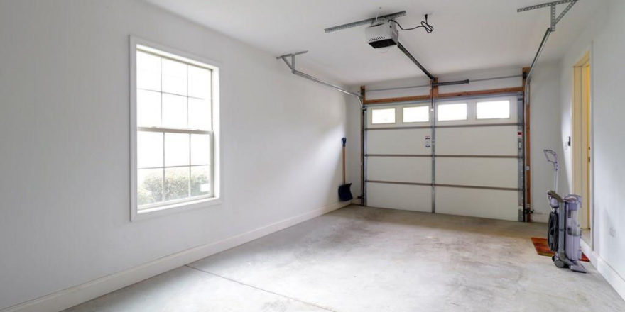 an empty garage with two windows and a door