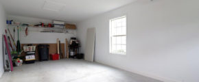 an empty room with a ceiling fan and a fire place