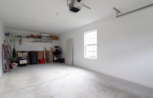 an empty room with a ceiling fan and a fire place