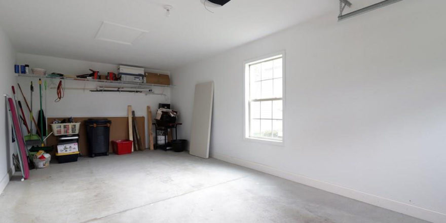 an empty room with a ceiling fan and a fire place