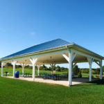 a covered picnic area with benches and tables