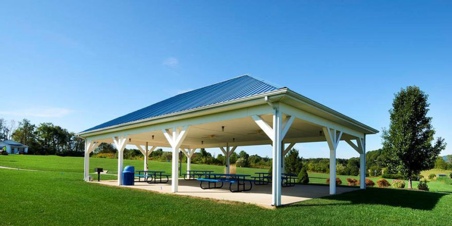 a covered picnic area with benches and tables