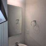 a bathroom with a sink, mirror and towel bar