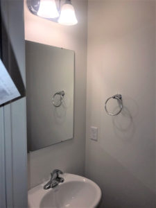 a bathroom with a sink, mirror and towel bar