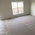 an empty room with carpeted floors and a window