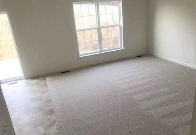 an empty room with carpeted floors and a window