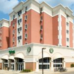 A luxury apartment building with a starbucks coffee shop on the corner