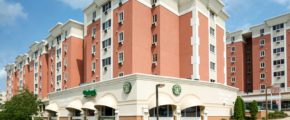 A luxury apartment building with a starbucks coffee shop on the corner