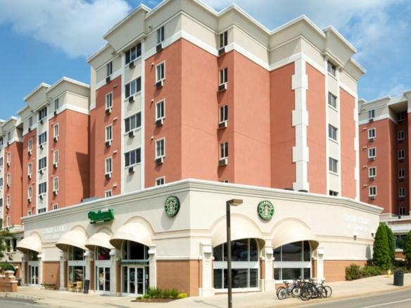 A luxury apartment building with a starbucks coffee shop on the corner