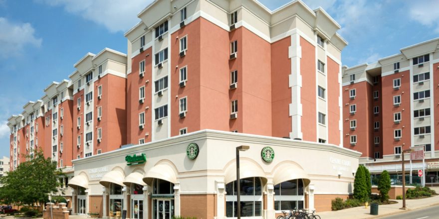 A luxury apartment building with a starbucks coffee shop on the corner