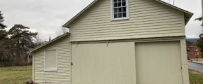 a yellow building with a large garage in front of it