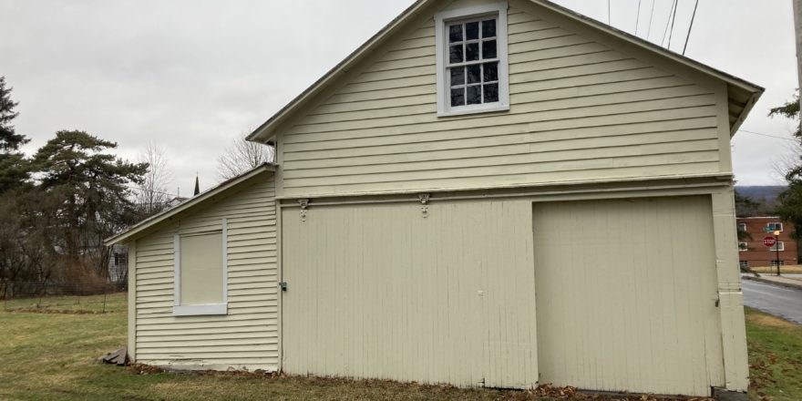 a yellow building with a large garage in front of it