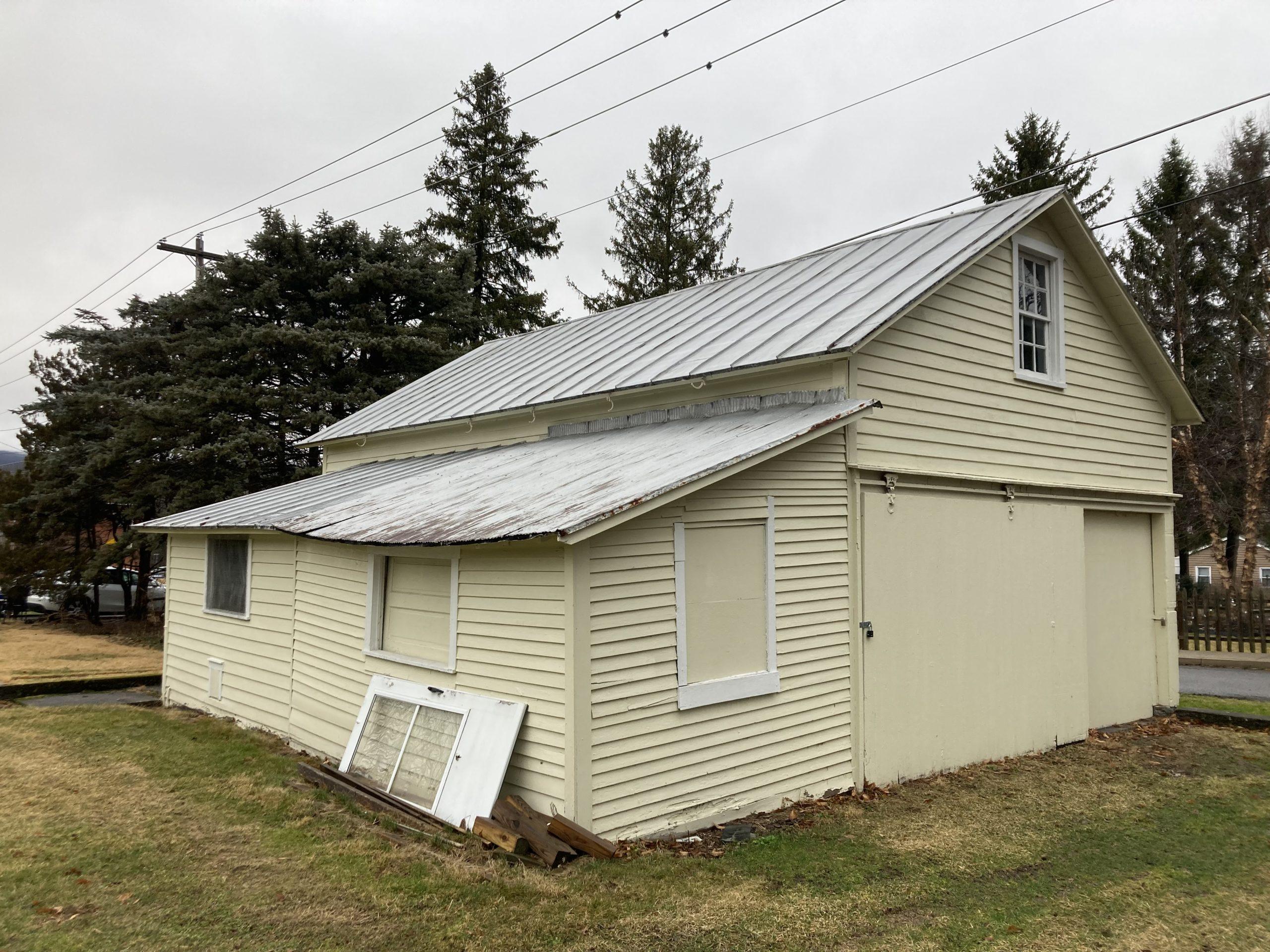 Yellow clapboard garage with sliding doors