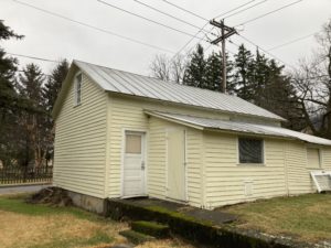 a small yellow building with a metal roof