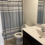 a bathroom with a sink, a white toilet and a bathtub shower