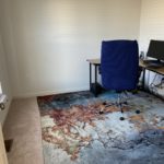 a room with a chair, desk, computer, and a window
