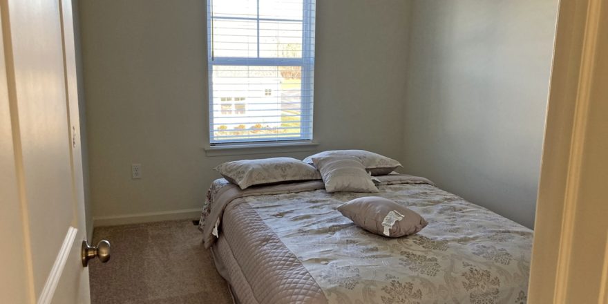 a bedroom with a bed and a window