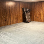 an empty room with beige carpet and wood paneling on the walls