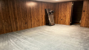 an empty room with beige carpet and wood paneling on the walls
