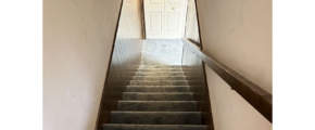 a set of stairs leading down to a closet door