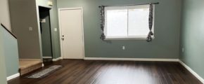 an empty living room with hard wood floors