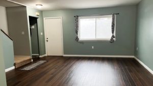 an empty living room with hard wood floors