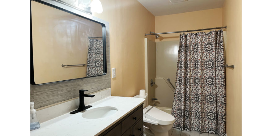 a bathroom with a shower, toilet and sink