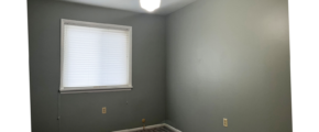 an empty room with light brown carpeting, a ceiling fan, and a window