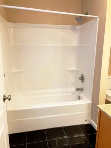 a bathroom with a white bath tub sitting next to a sink