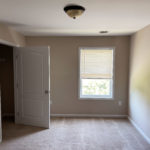 an empty room with a closet and a window