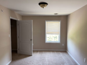 an empty room with a closet and a window