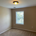 an empty room with a window and no curtains