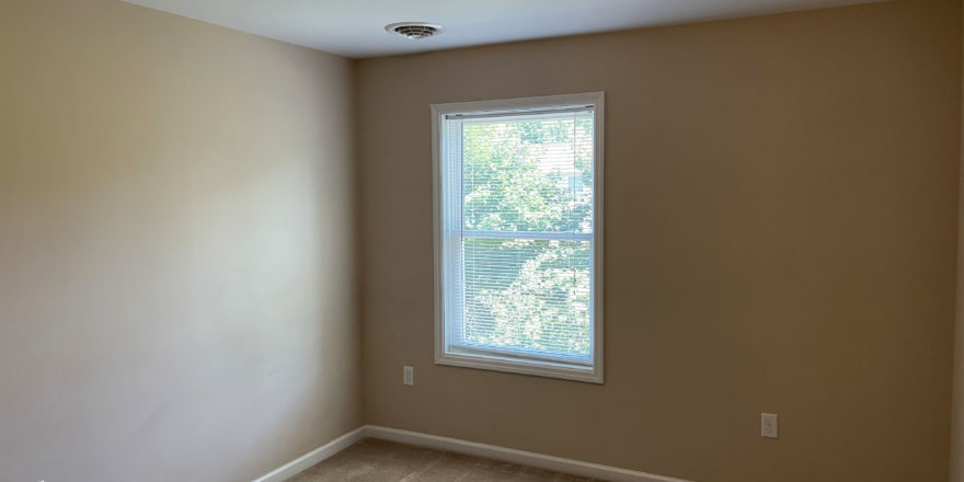 an empty room with a window and no curtains