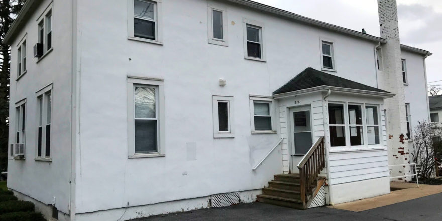 a white house with a car parked in front of it