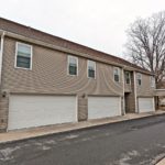 two story townhouse building with garages on each side